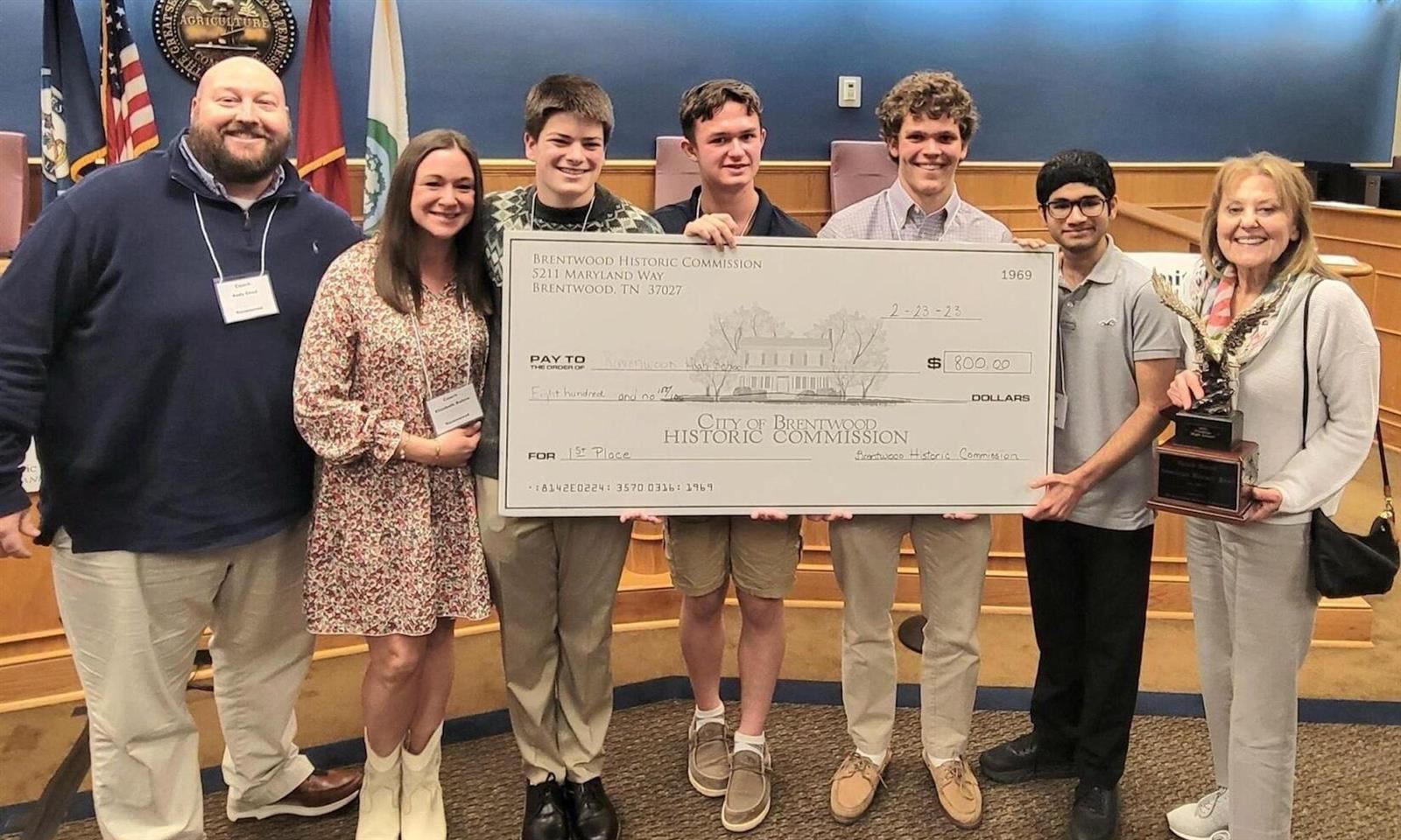 Students and teachers holding a large check